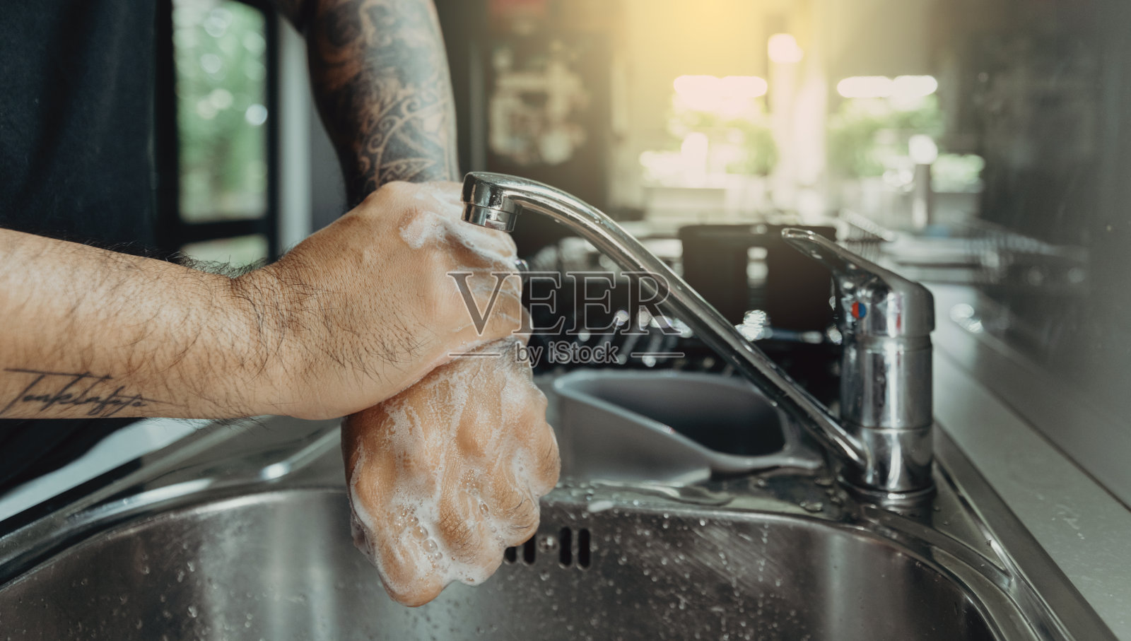 男子用泡沫洗手液洗手，预防新冠病毒，保持卫生以阻止病毒传播照片摄影图片