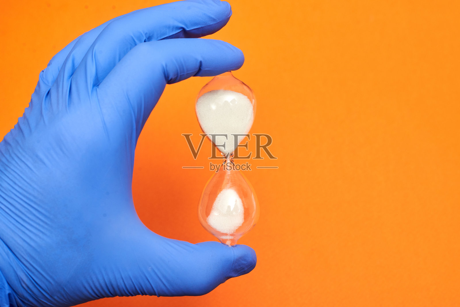 医生手里拿着沙漏。医学和时间概念。照片摄影图片