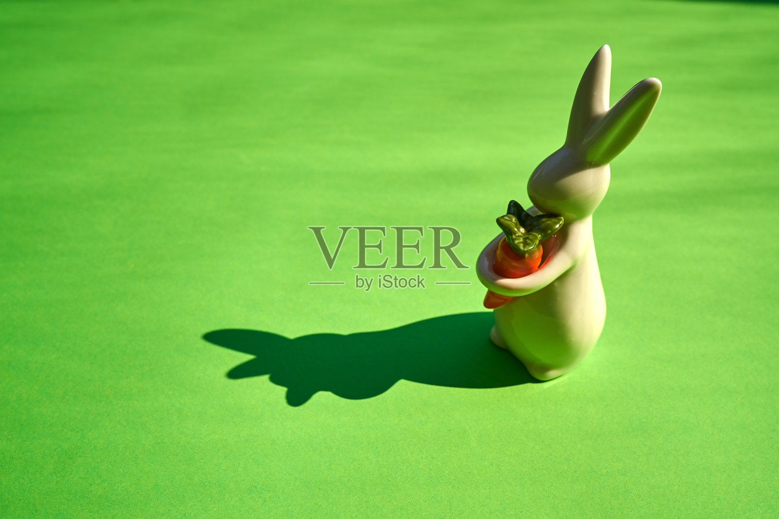 白色复活节兔子在绿色的纸背景照片摄影图片