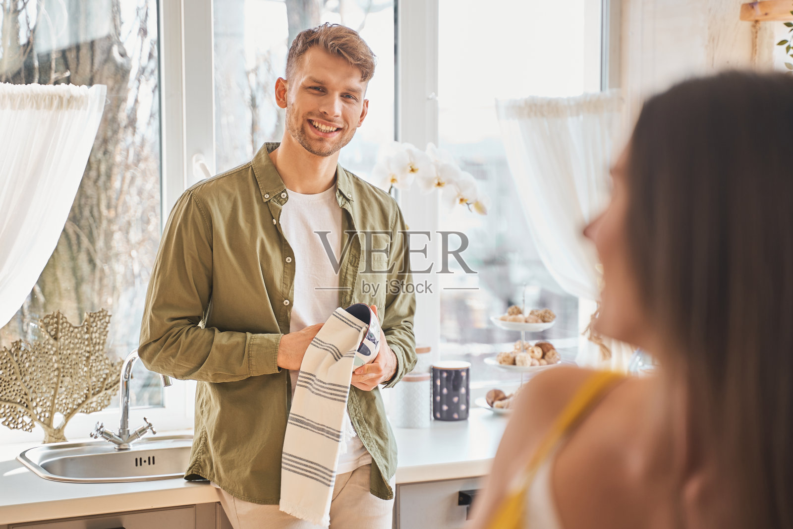 开朗的年轻人正在擦干净碗照片摄影图片