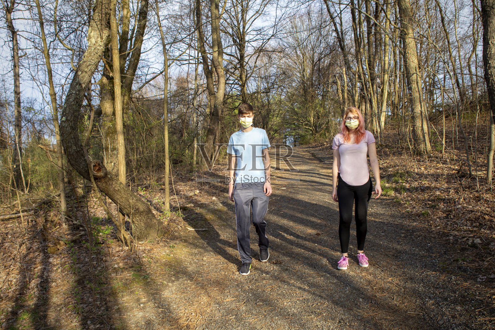 戴着口罩的哥哥和妹妹在户外散步照片摄影图片