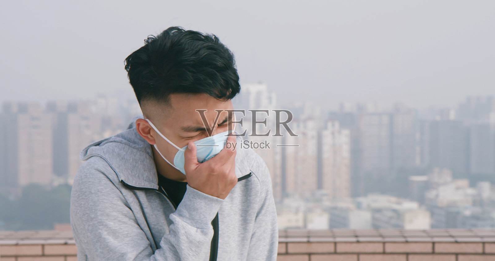 男人咳嗽，戴着口罩照片摄影图片