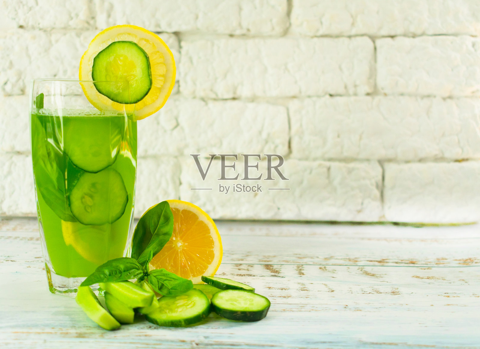 一杯健康的黄瓜柠檬汁，用罗勒叶装饰。饮食的概念。有益的夏季清爽饮料减肥。副本的空间。照片摄影图片