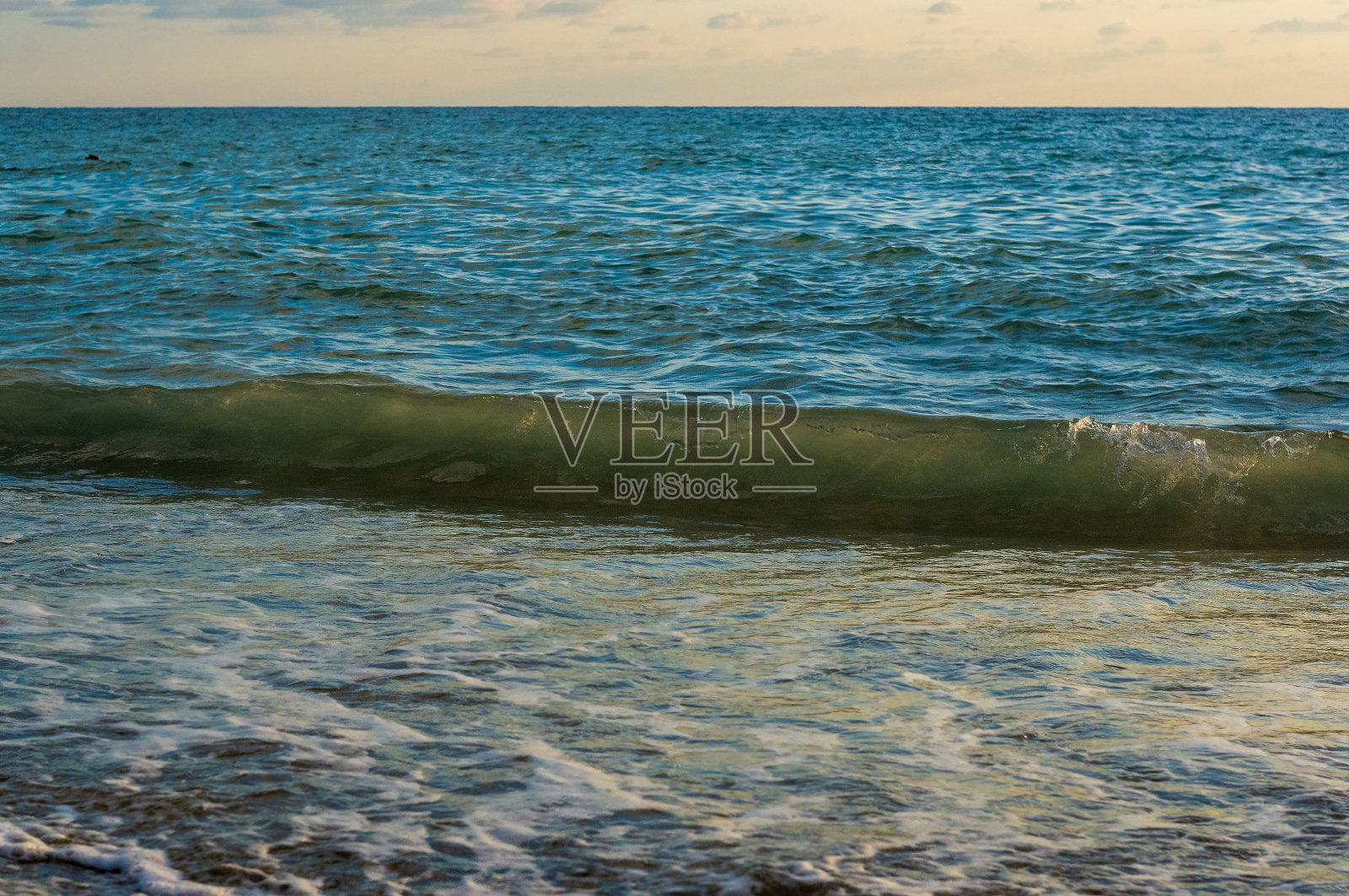 卵石滩上惊人的海上日落，太阳，海浪，云彩照片摄影图片