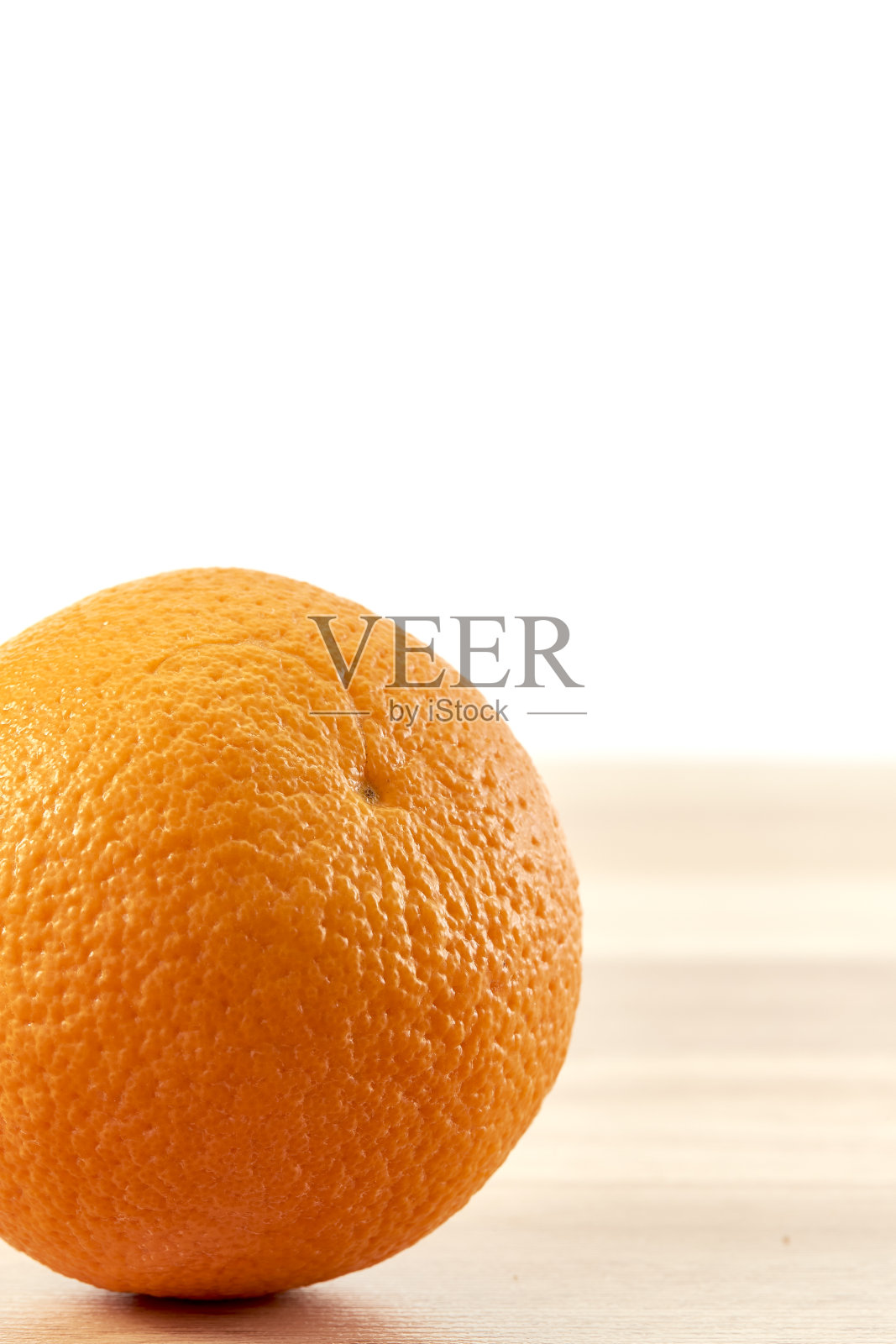 新鲜的橘子水果放在木桌上，与白色的墙壁背景隔开照片摄影图片