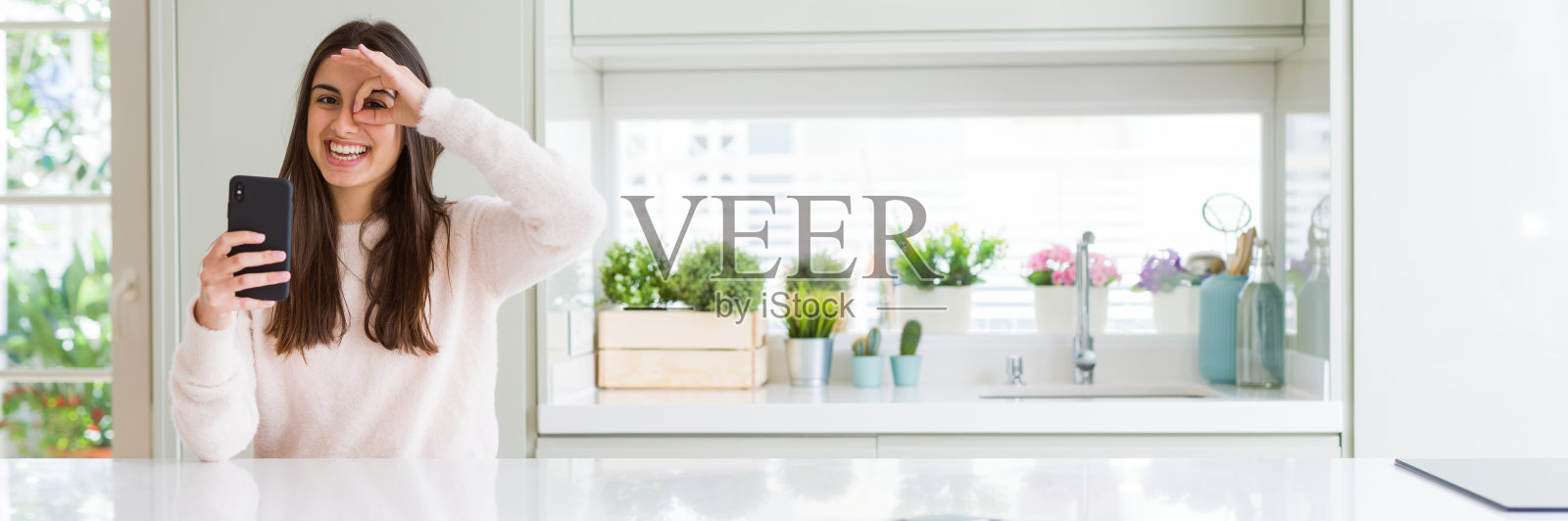 年轻女子用智能手机发送信息，面带微笑照片摄影图片