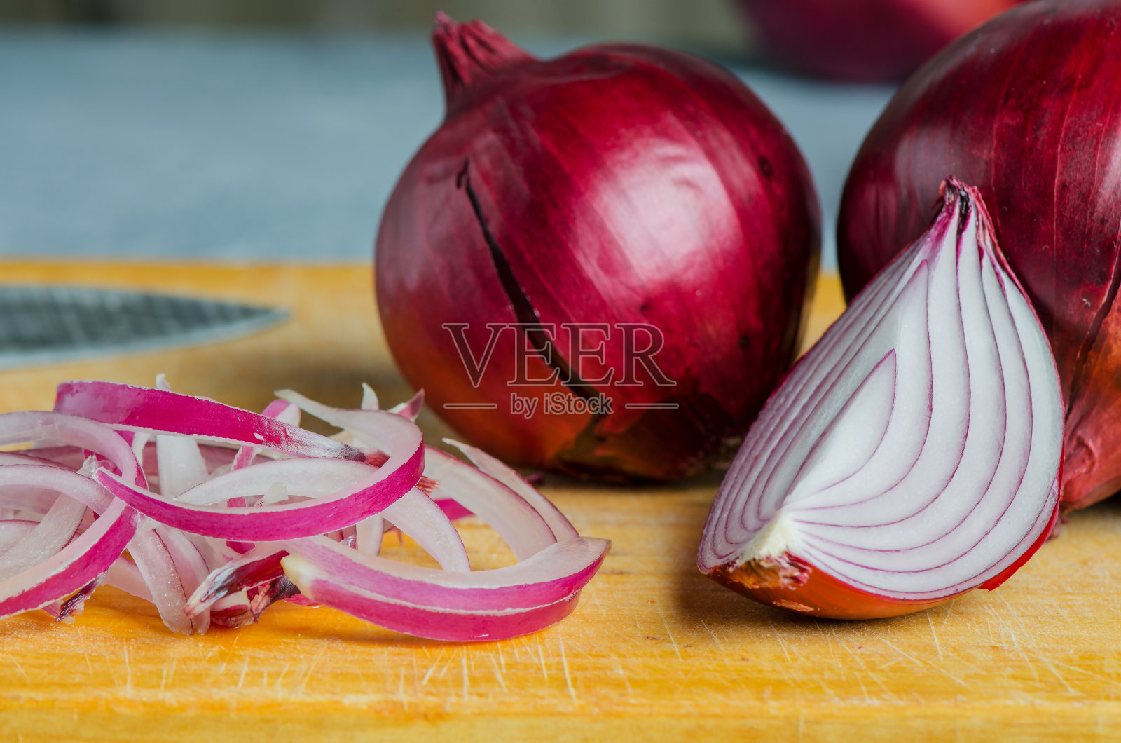 红洋葱切片。在黄色砧板上烹饪的过程。照片摄影图片
