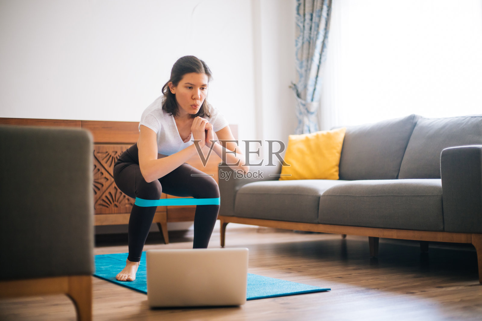 喜欢运动的年轻女子在家里带着反抗乐队锻炼照片摄影图片