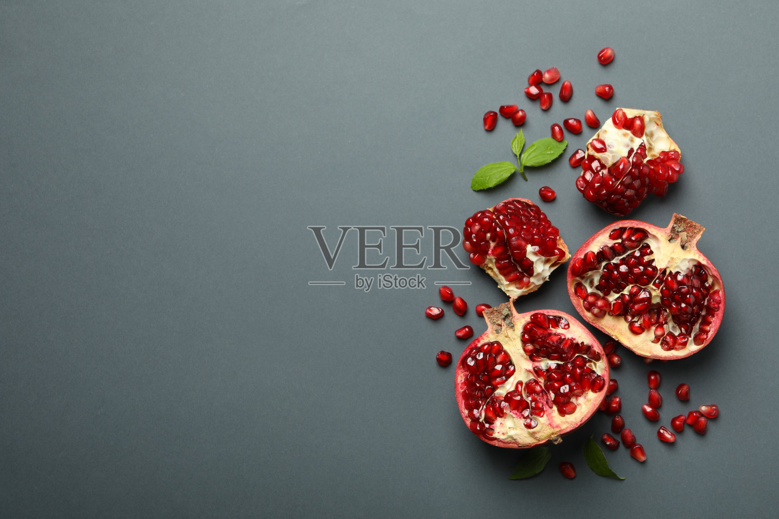 石榴，叶子和种子在灰色背景，俯视图照片摄影图片