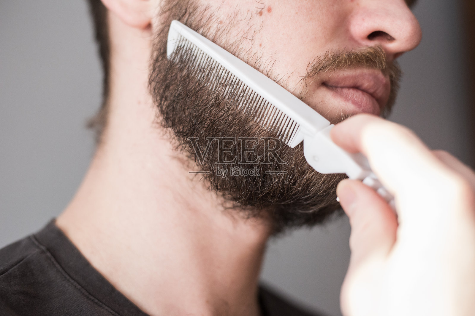 一个男人用梳子梳理他的胡子照片摄影图片