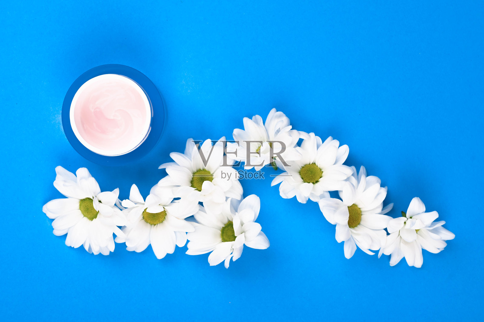 天然化妆品的概念。花和一罐奶油。心形甘菊和一罐奶油。从以上观点。天然的化妆品。记录的地方照片摄影图片