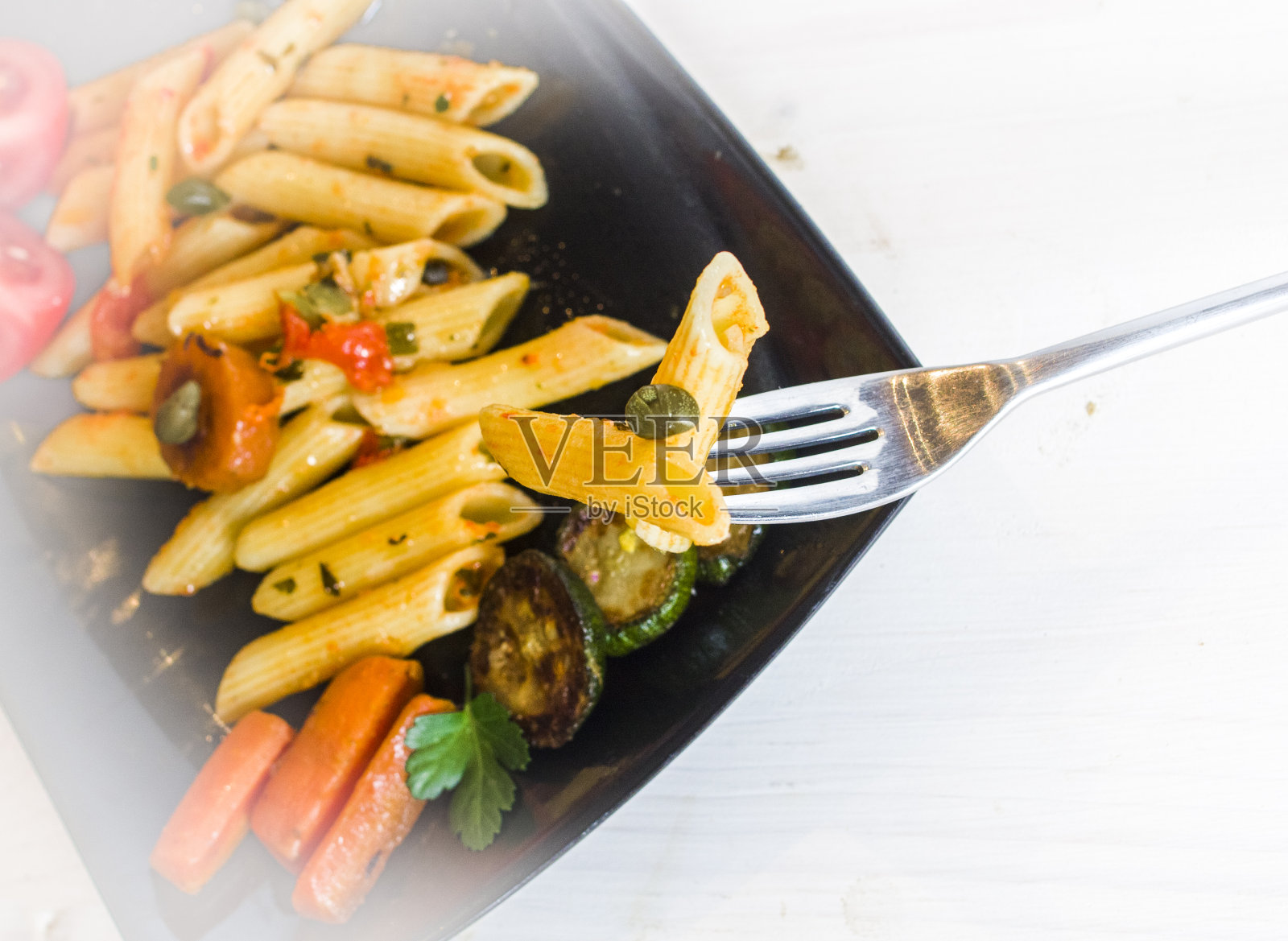 意大利面配上色彩鲜艳、营养丰富的蔬菜和酸豆照片摄影图片