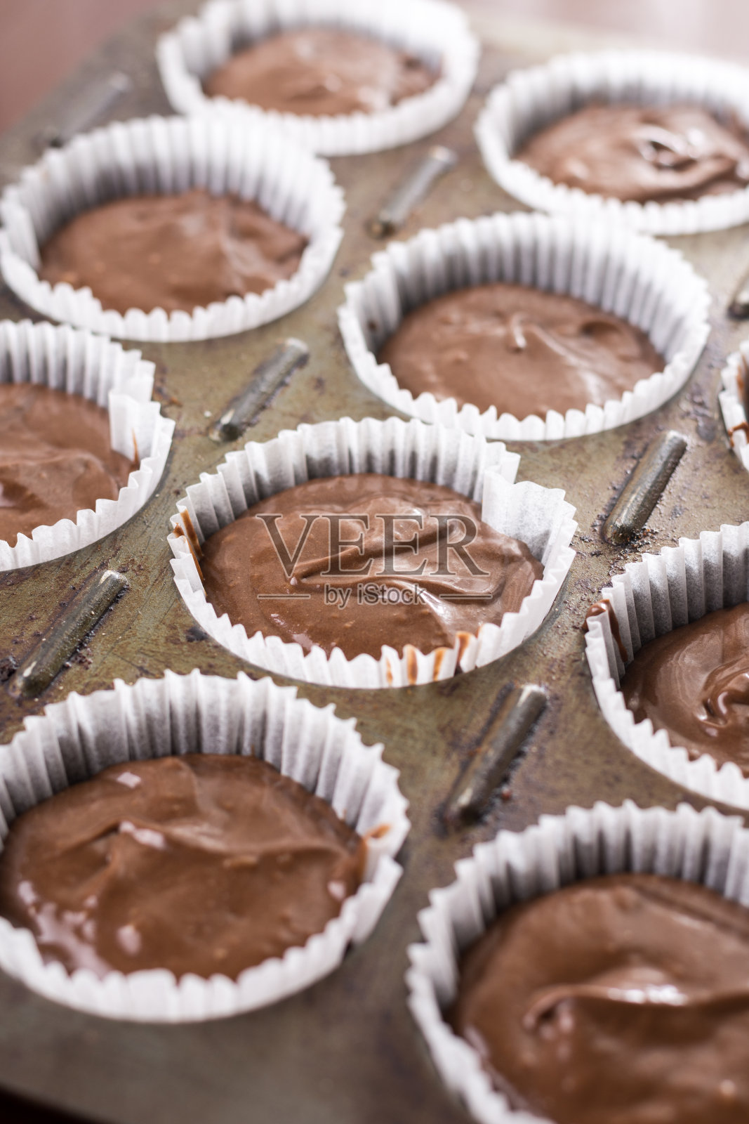 生巧克力杯蛋糕混合物在杯蛋糕纸上准备烘烤照片摄影图片