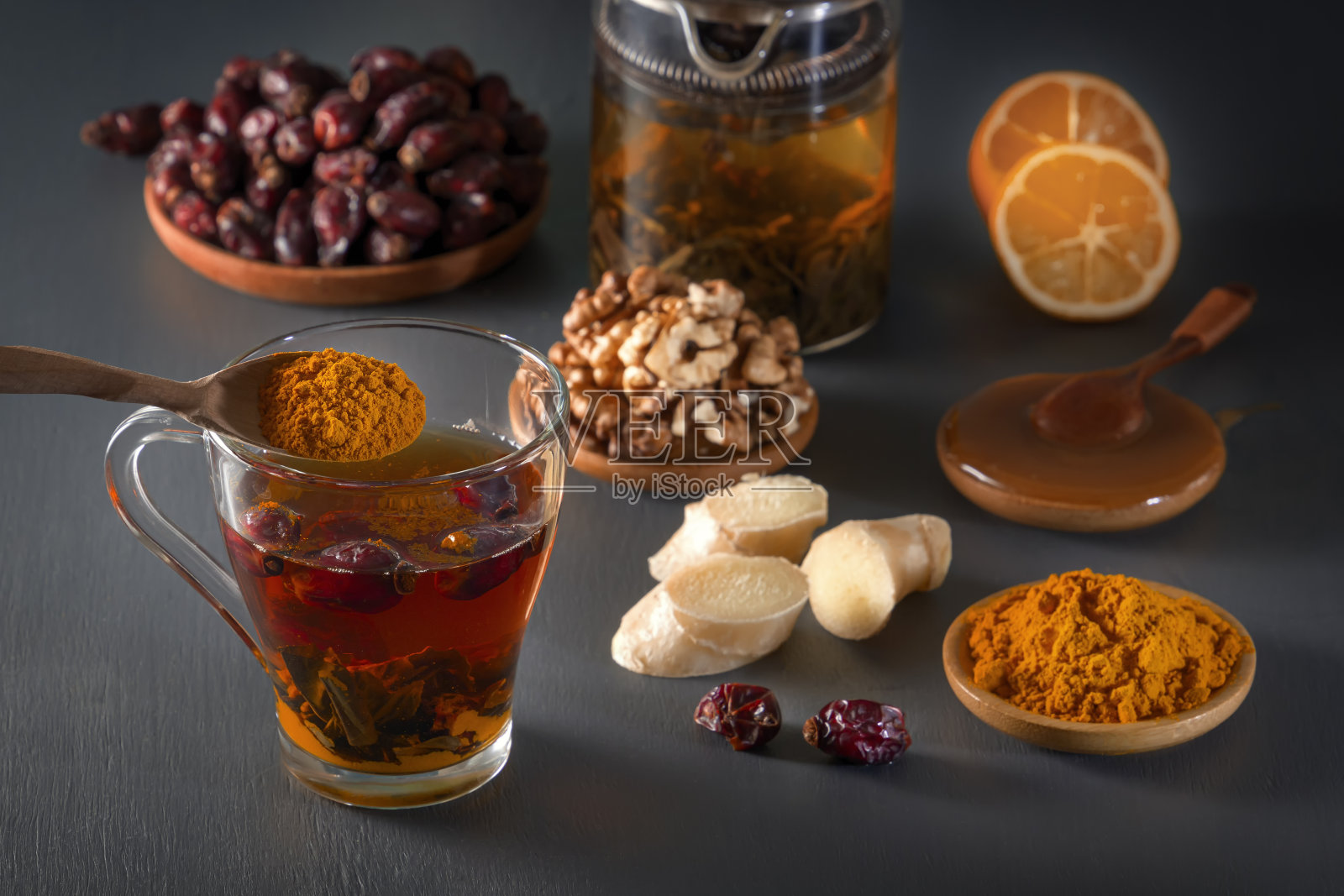 玻璃杯中草药茶，姜，核桃，姜黄，蜂蜜，柠檬和干玫瑰果——一种提高免疫力的方法照片摄影图片