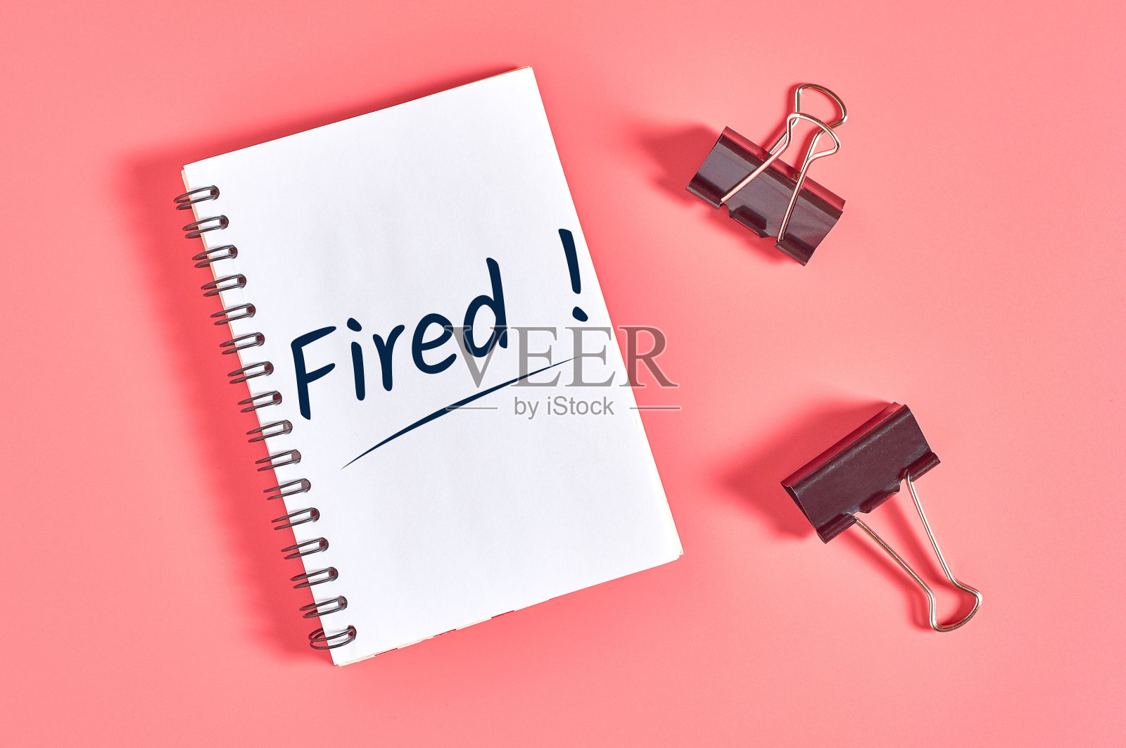 粉红色书桌上的纸笔记本，在活页夹旁边放着文字。就业的概念照片摄影图片