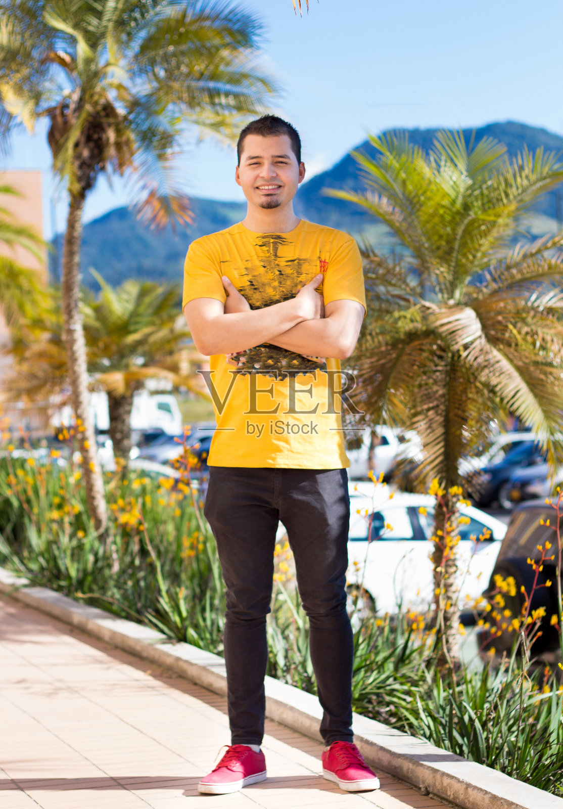 小男孩微笑着，身后是棕榈树，感觉很成功照片摄影图片