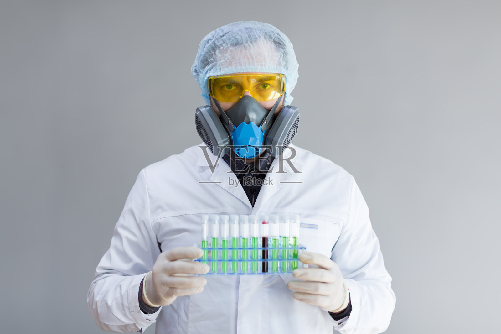 这是一张医学研究人员拿着一个试管支架的照片，手上拿着血液和病毒样本。照片摄影图片