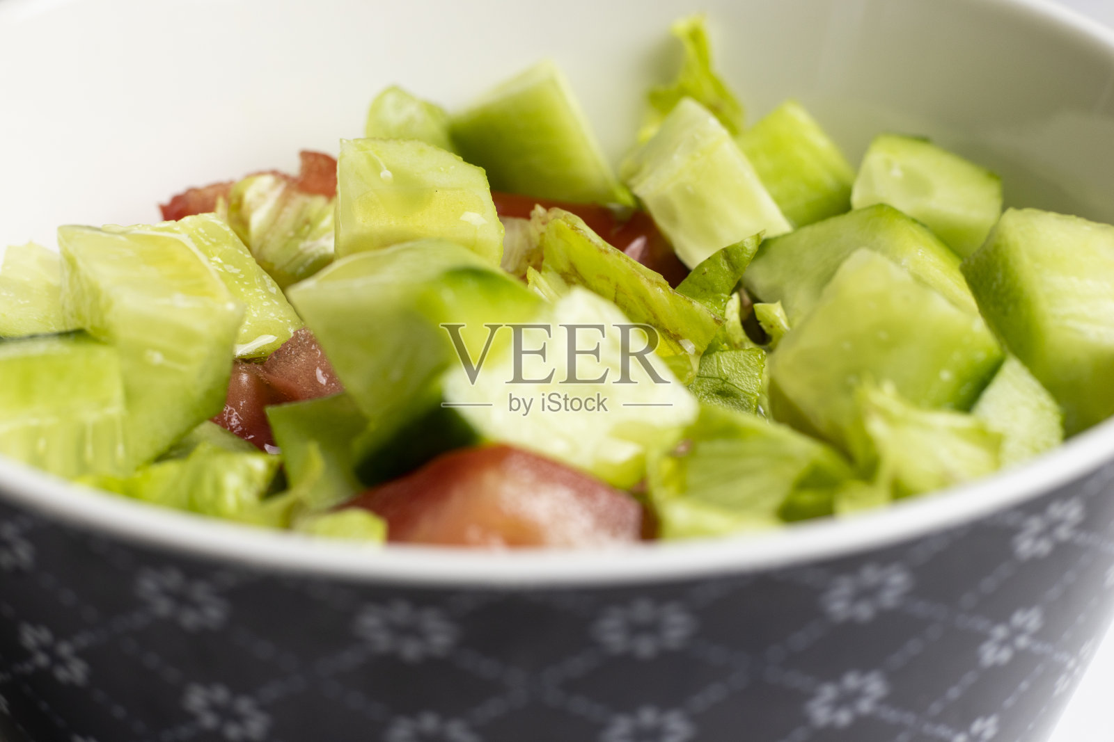 盘子上的沙拉特写。黄瓜，番茄和莴苣。照片摄影图片