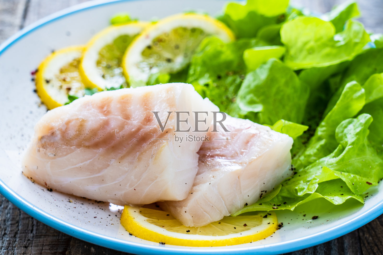 新鲜的生鳕鱼片放在木桌上照片摄影图片