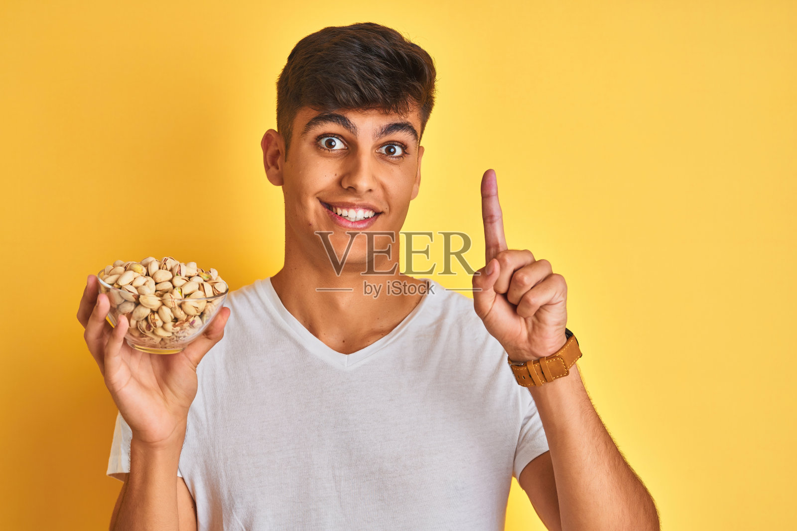 拿着开心果的印度年轻男子有了新想法照片摄影图片