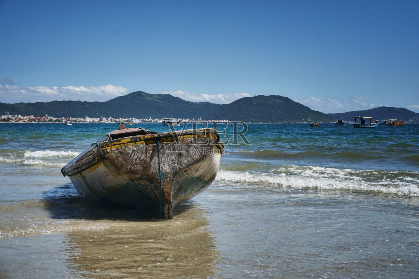 海滩在阳光明媚的日子里有海鸥，小船和沙滩上有小船搁浅在沙滩上。彩色照片照片摄影图片