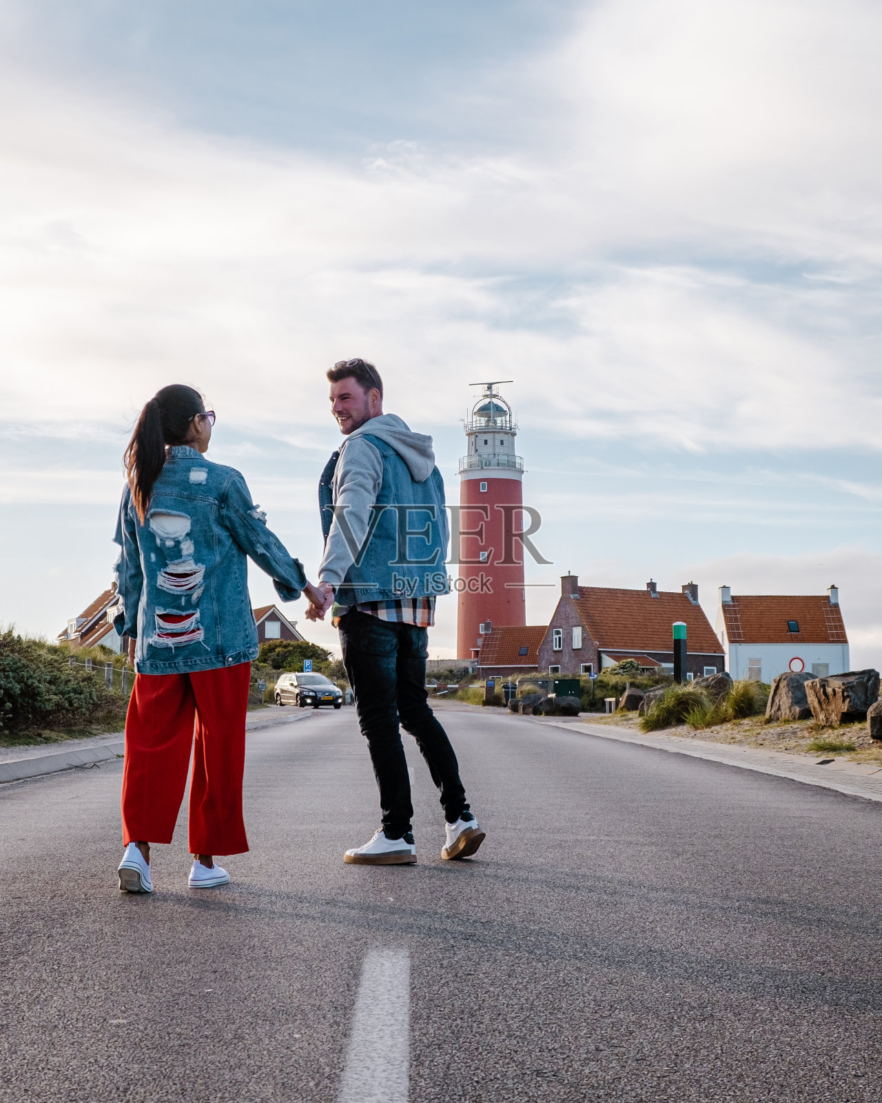 荷兰的特塞尔岛，一对夫妇参观灯塔，男男女女在特塞尔度假照片摄影图片