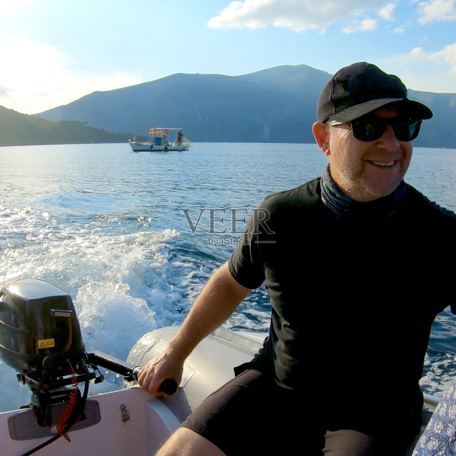 中年水手驾驶一艘补给船回到他的游艇照片摄影图片