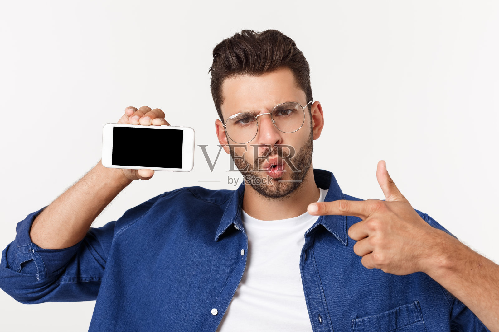 年轻人展示他的全新智能手机孤立在白色。照片摄影图片