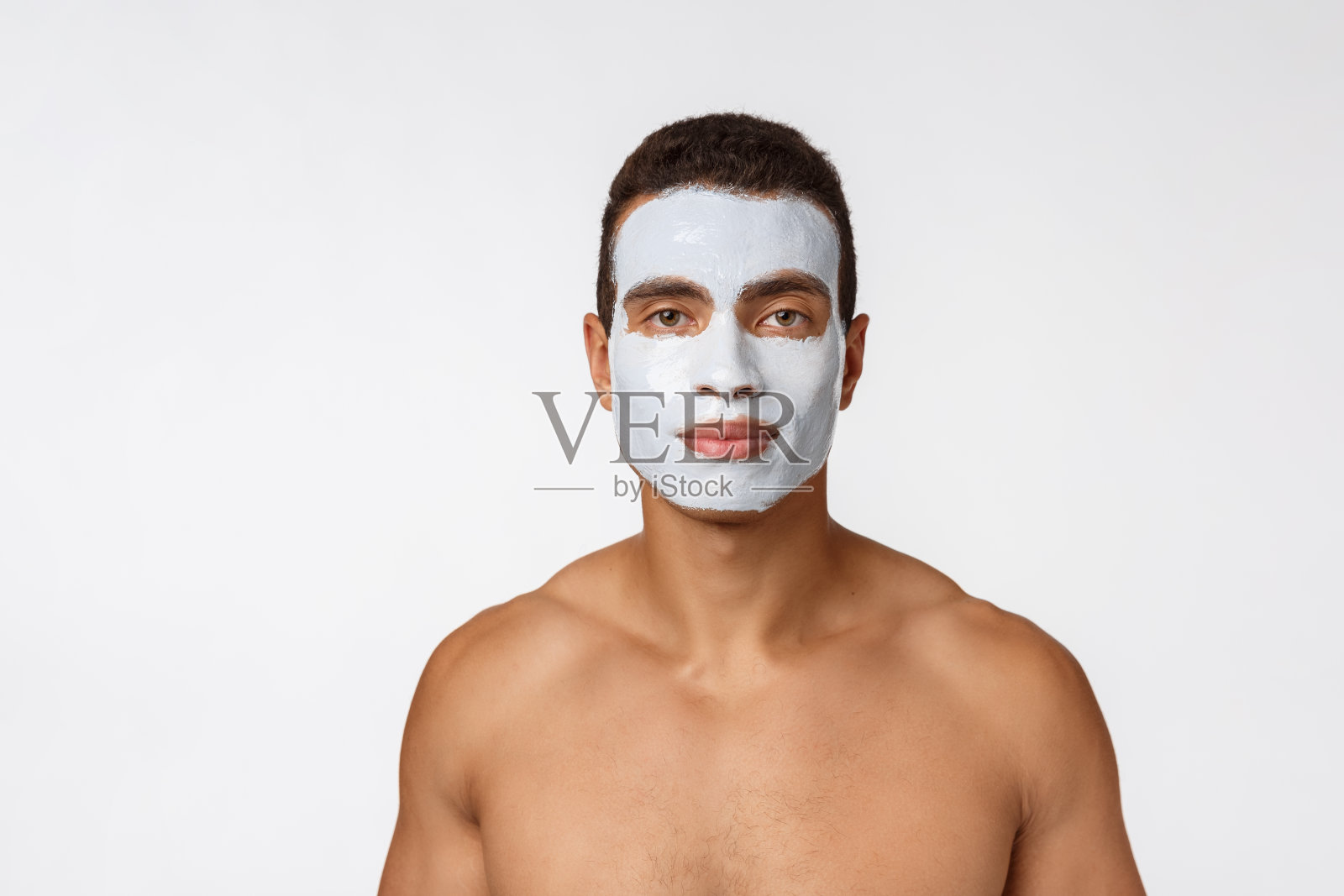 这是一个开朗的非洲小伙子在镜头前微笑的照片。一个脸上戴着奶油面膜的男人的肖像。美程照片摄影图片