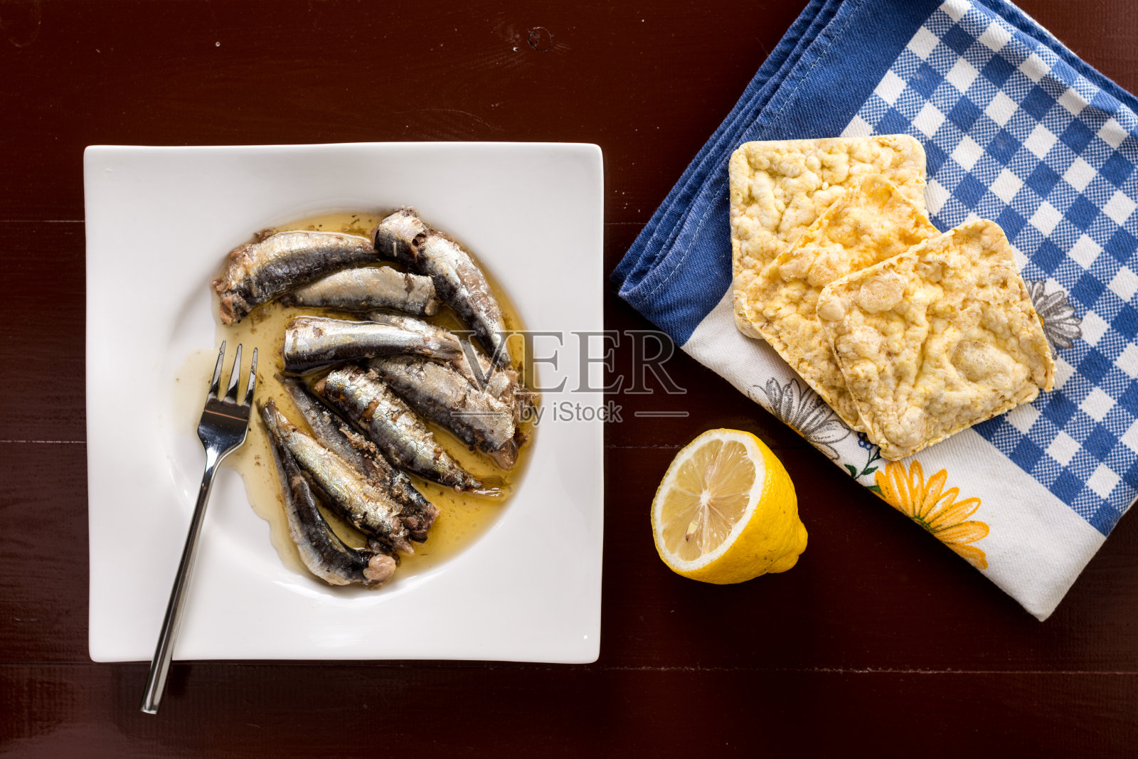 油浸过的沙丁鱼配上柠檬和玉米面包照片摄影图片
