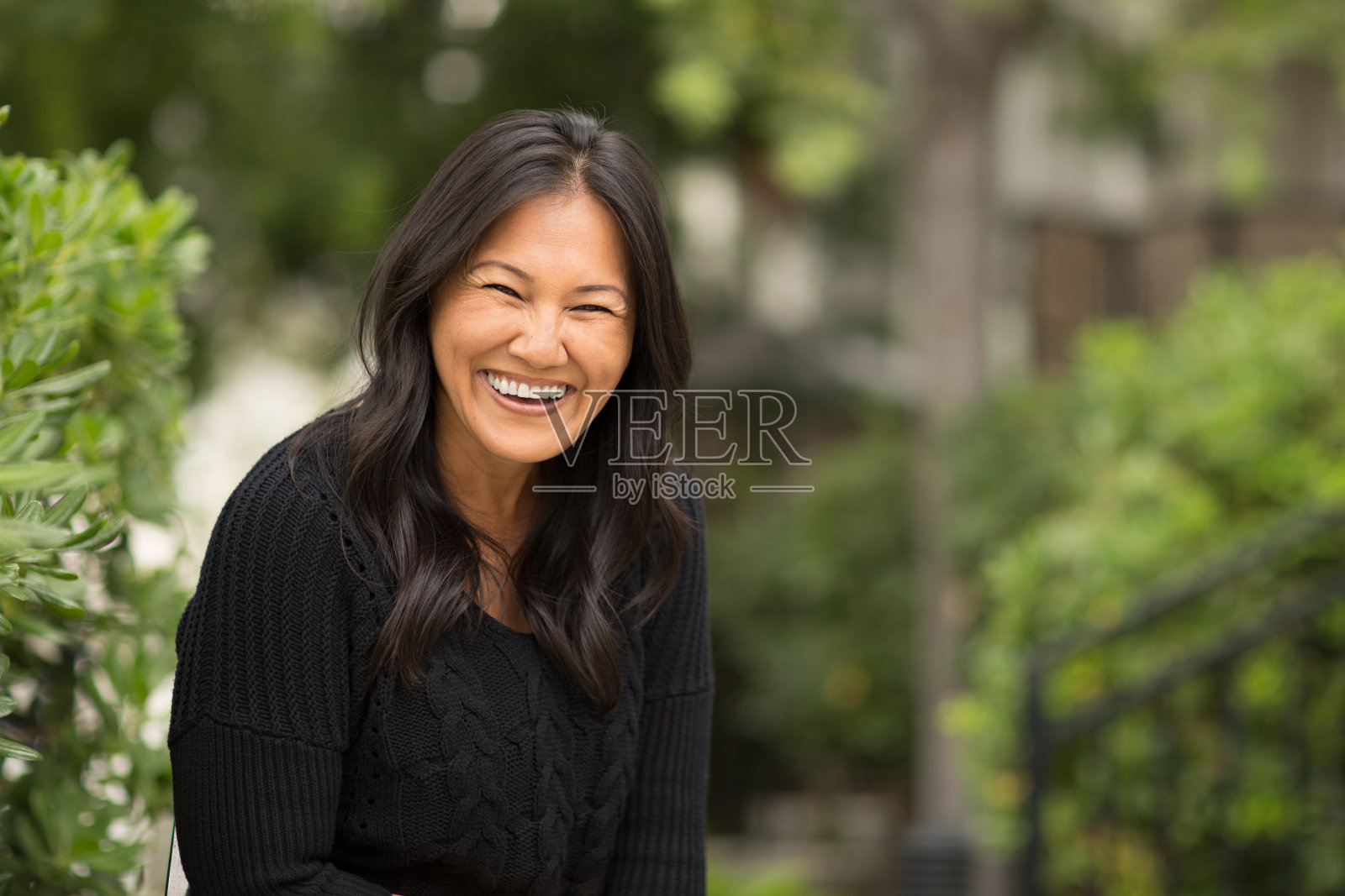 一个坐在外面的亚洲女人的肖像。照片摄影图片