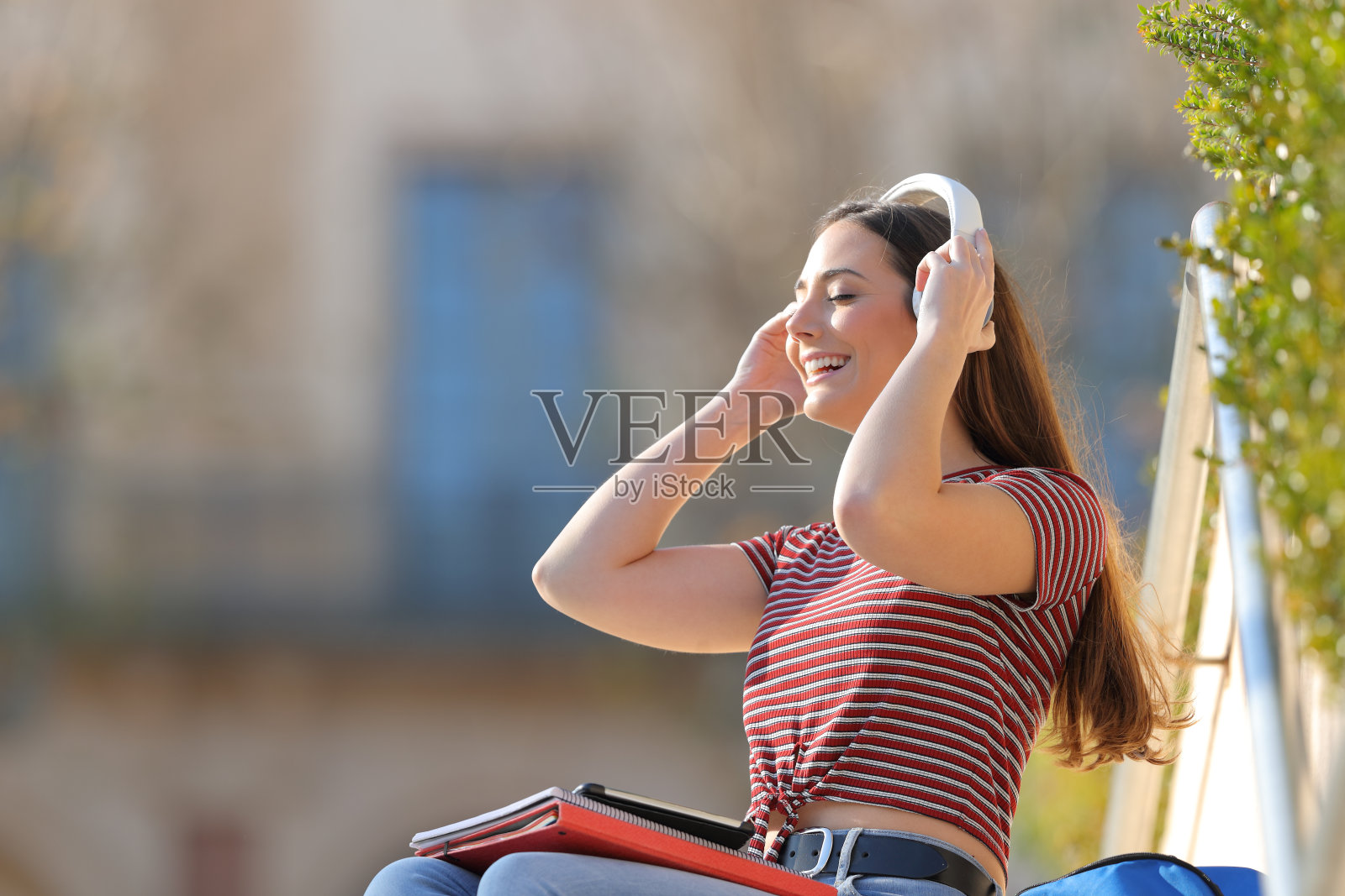 快乐的学生在校园里戴耳机照片摄影图片