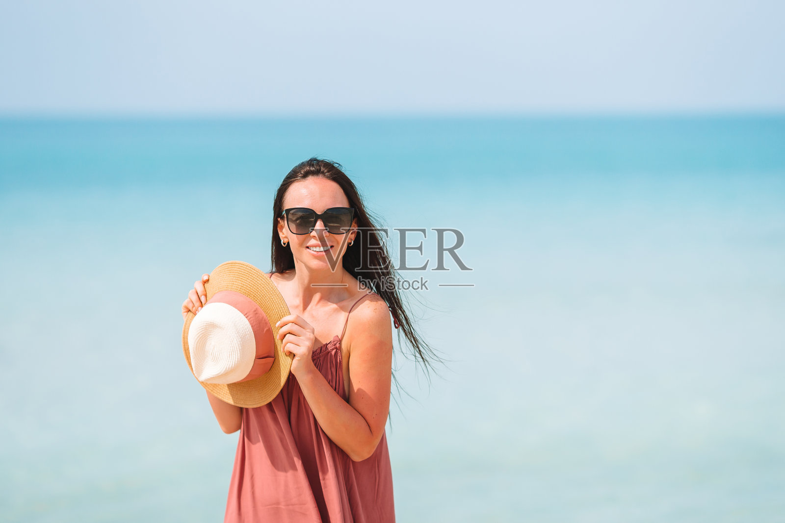 快乐的女孩背景是蓝天和碧绿的海水照片摄影图片