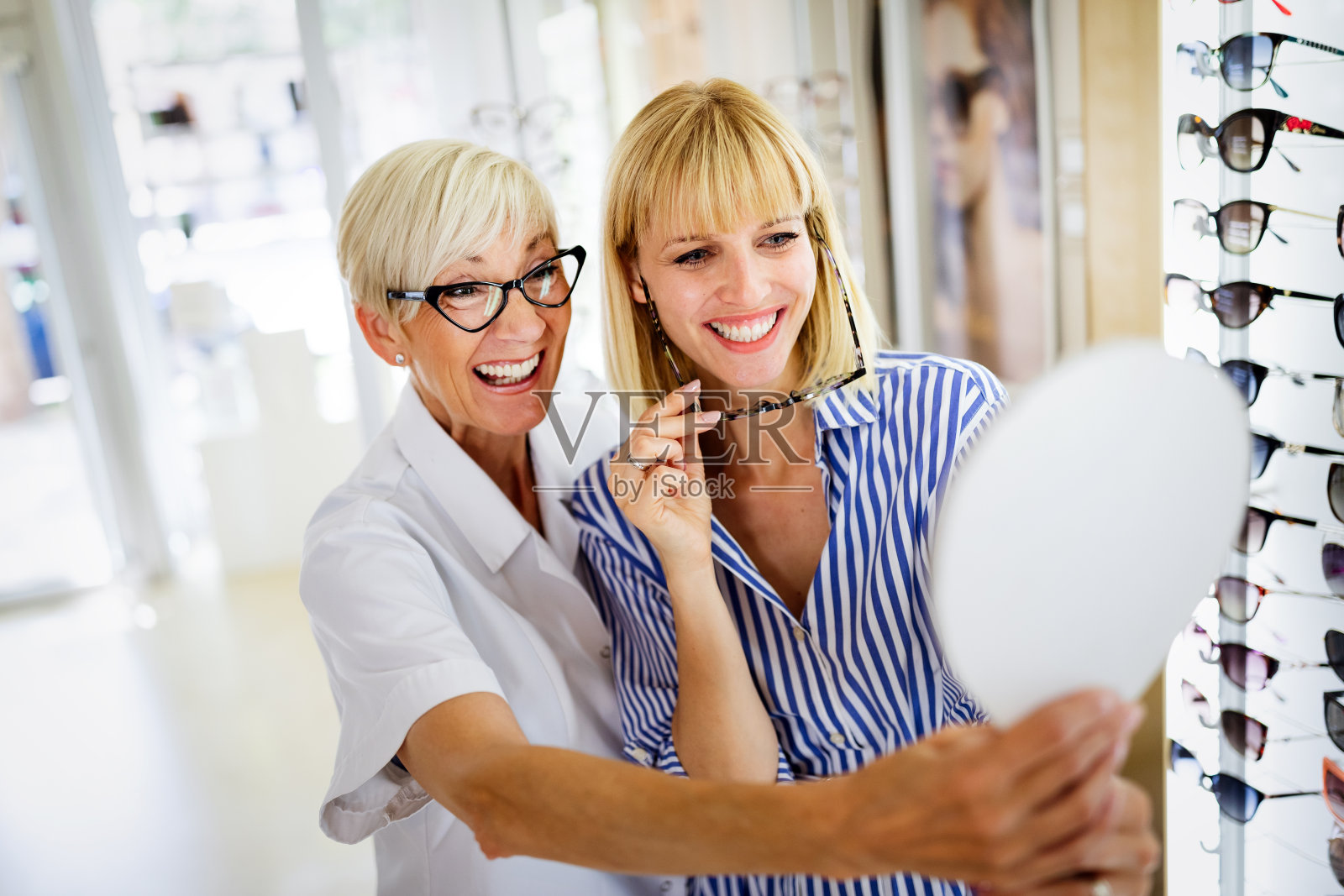 保健、视力和视觉理念。快乐的女人在光学商店选购眼镜照片摄影图片