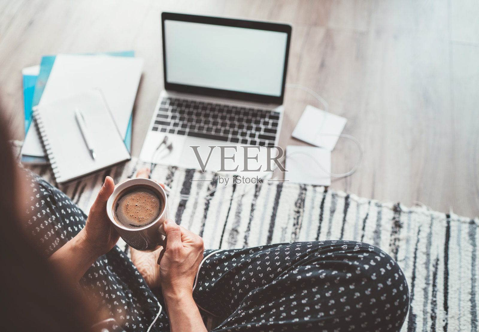 女商人穿着睡衣享受早上的咖啡在地板办公室与笔记本电脑，报纸俯视图拍摄。远程记者或作家在世界范围内隔离时间概念工作。照片摄影图片