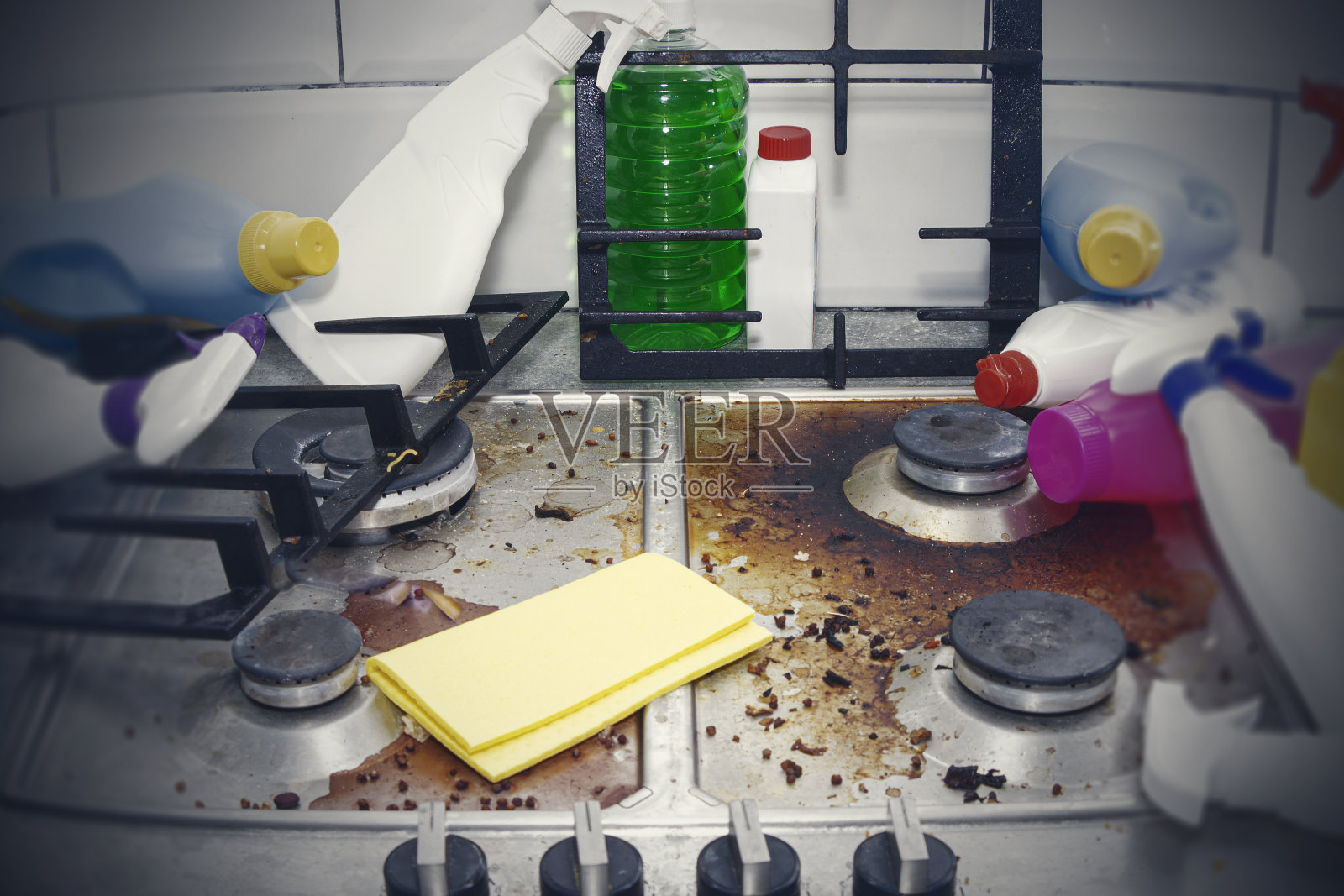 厨房的炉子很脏，到处都是空的和满的洗涤剂瓶子。照片摄影图片