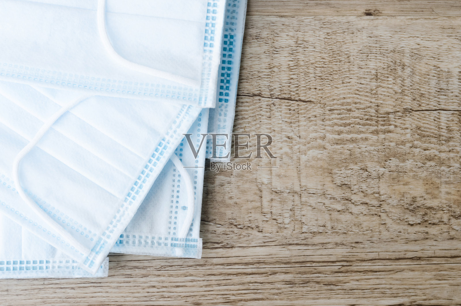 医用口罩，医用防护口罩以木质纹理为背景。一次性外科口罩盖住口鼻。医疗保健和医学概念背景。照片摄影图片