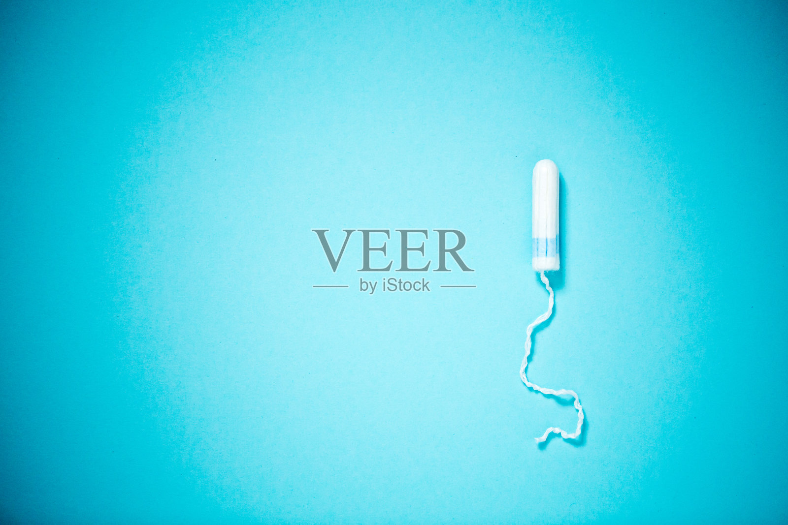 医用女性卫生棉条，蓝色背景，有拷贝空间。卫生的白色女性卫生棉条。棉拭子。月经，是保护的手段。照片摄影图片