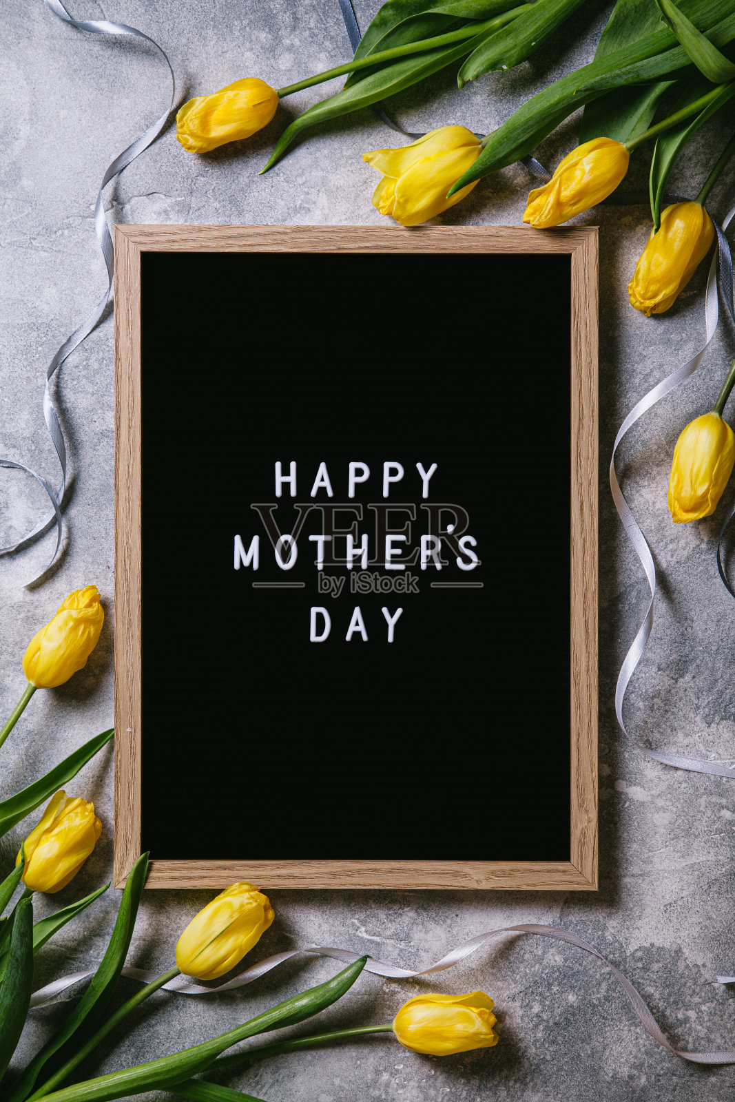 灰色背景上的郁金香和字母板。母亲节。照片摄影图片
