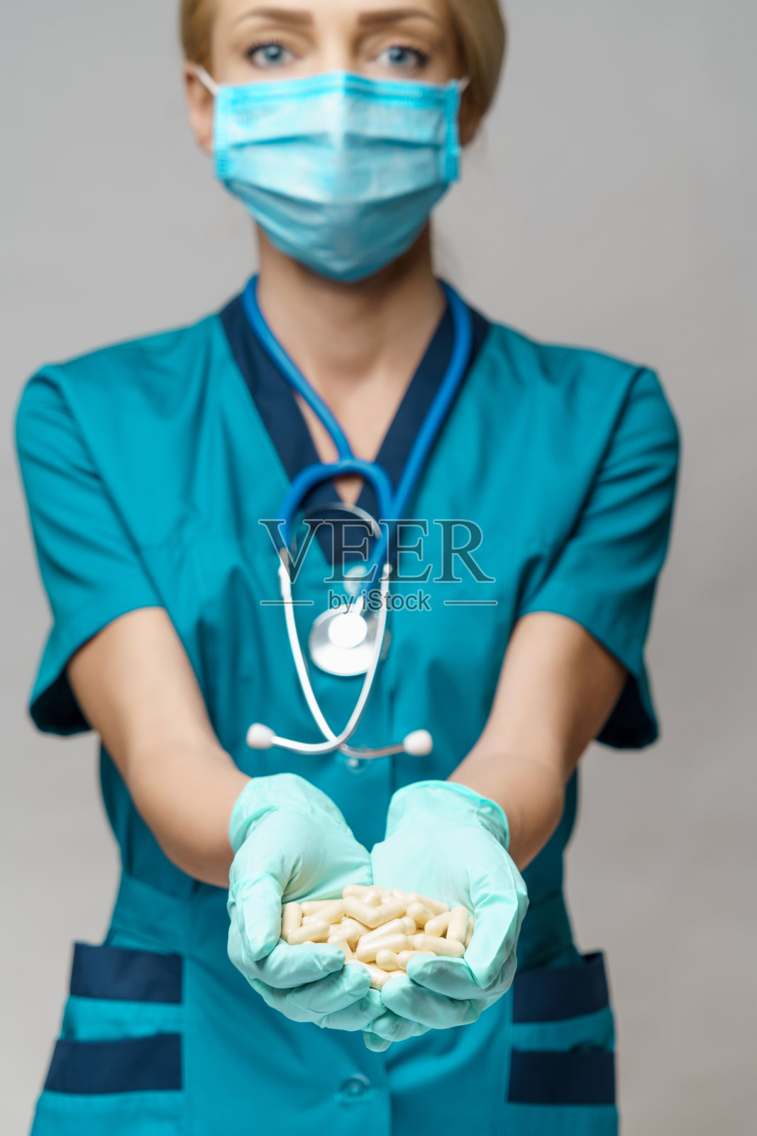 医生护士妇女戴着防护面具和橡胶或乳胶手套-持有药丸照片摄影图片