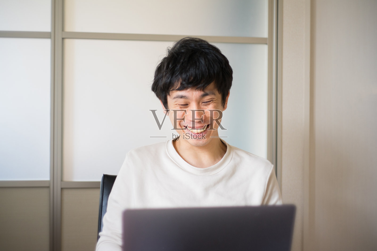 男男女女坐在家里的沙发上用笔记本电脑进行有趣的视频通话照片摄影图片