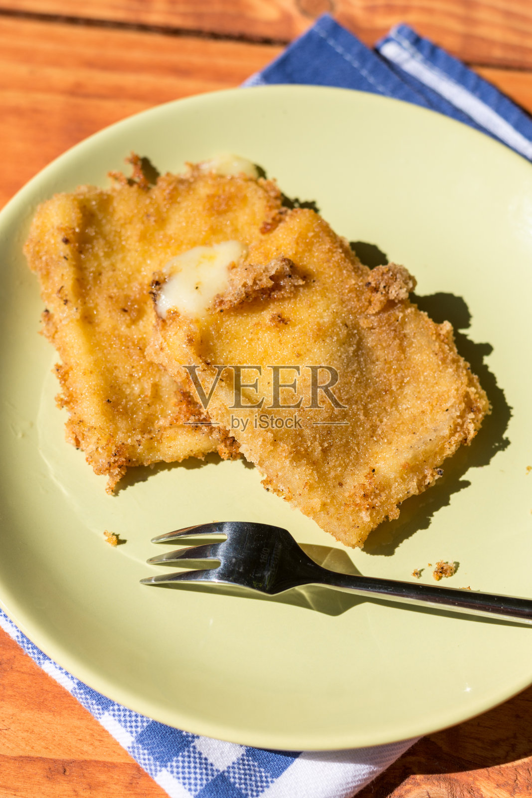 煎奶酪蛋用金属叉盛在盘子里照片摄影图片