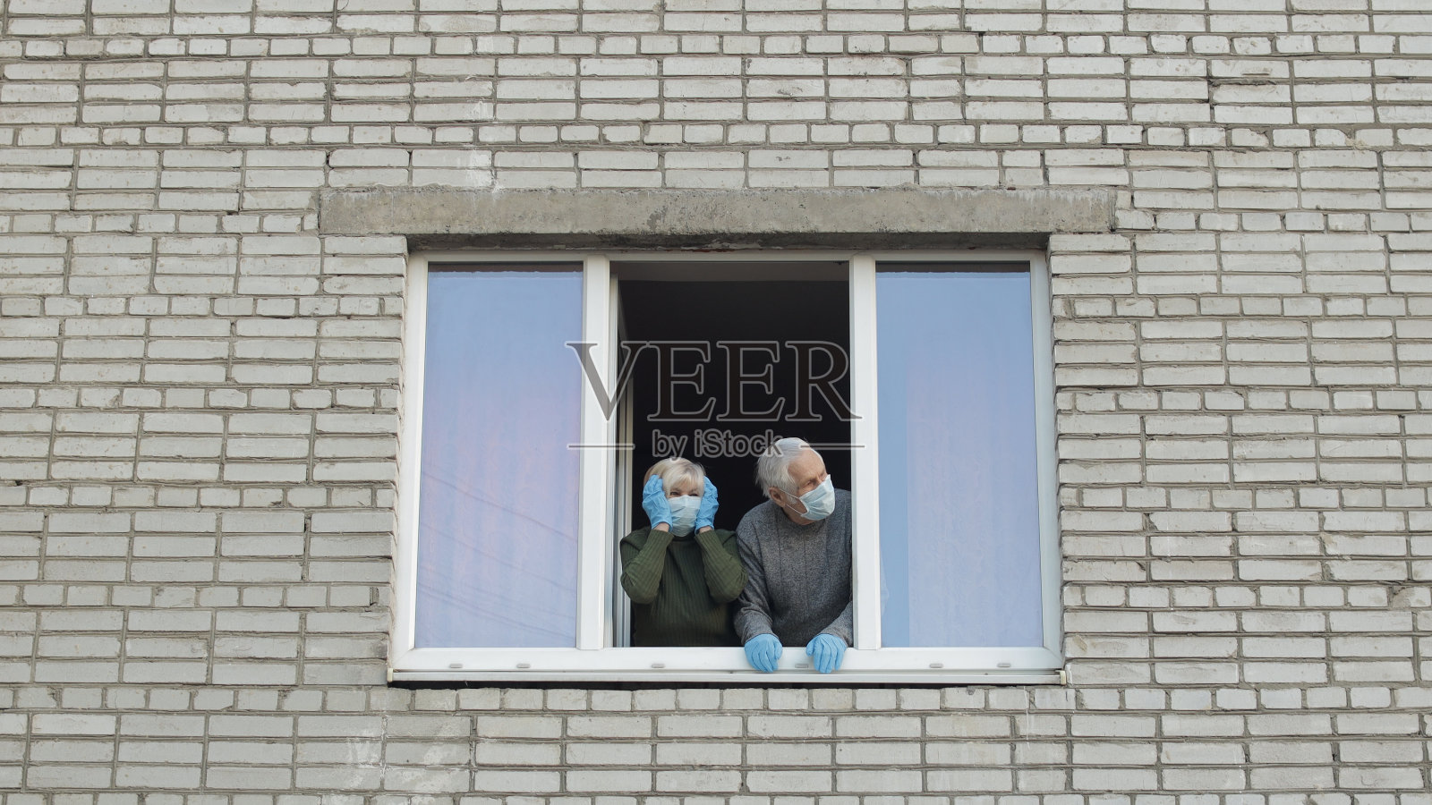 年迈的祖父母呆在家里的窗户隔离隔离。冠状病毒照片摄影图片