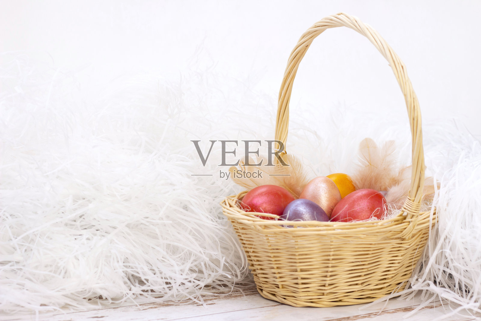 复活节彩蛋。复活节时放在篮子里的彩蛋。在一个灯光背景上，木制的背景。照片摄影图片