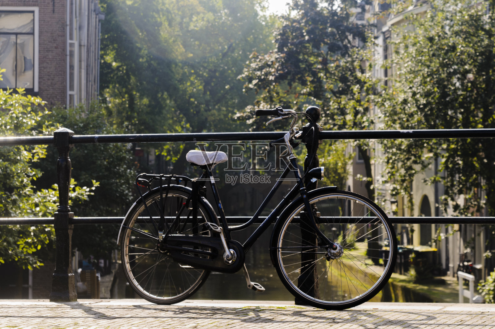 荷兰乌得勒支运河上的桥上骑着一辆自行车照片摄影图片