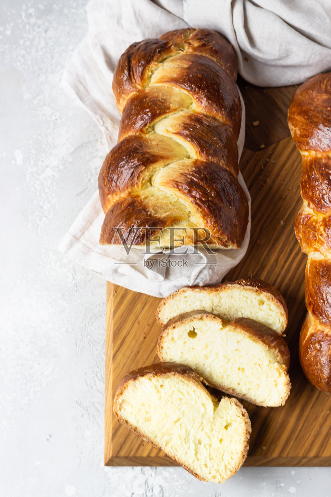 木板上的自制犹太面包或甜面包，浅灰色石材背景照片摄影图片