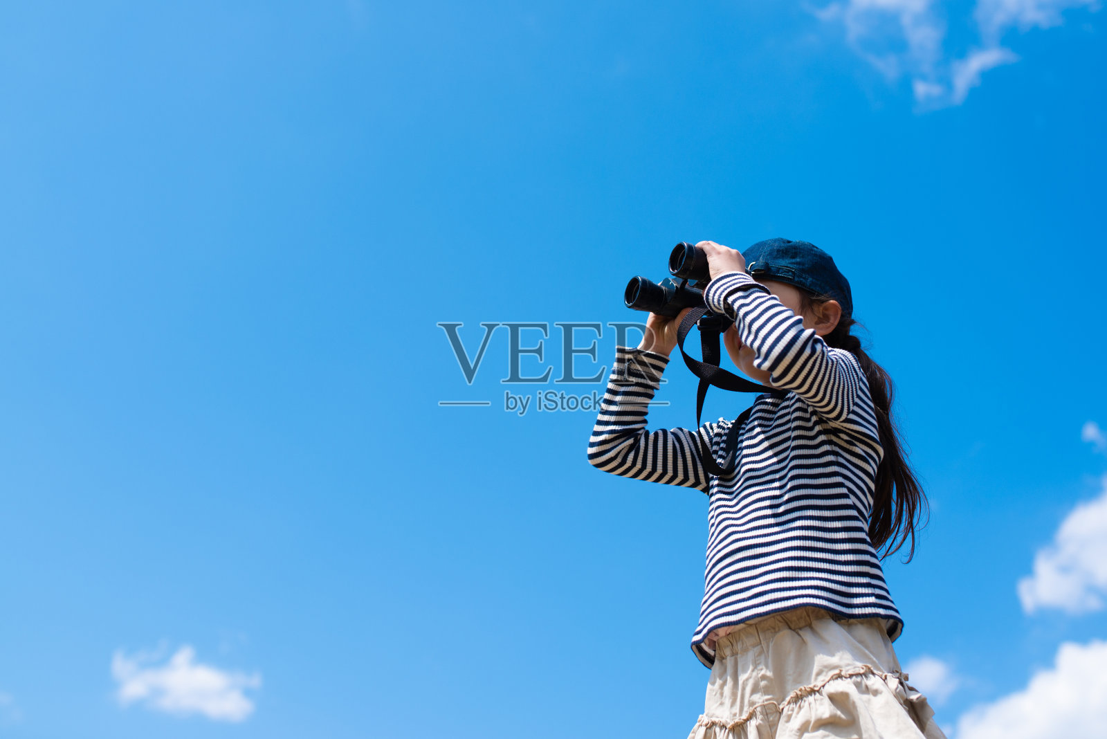 孩子用双筒望远镜看远照片摄影图片
