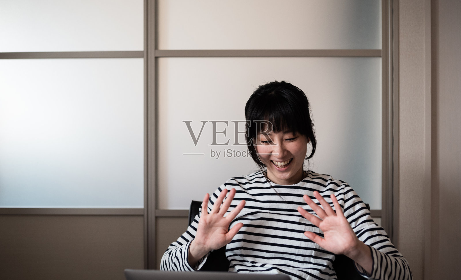 一个亚洲女人在用笔记本电脑开视频会议的照片照片摄影图片