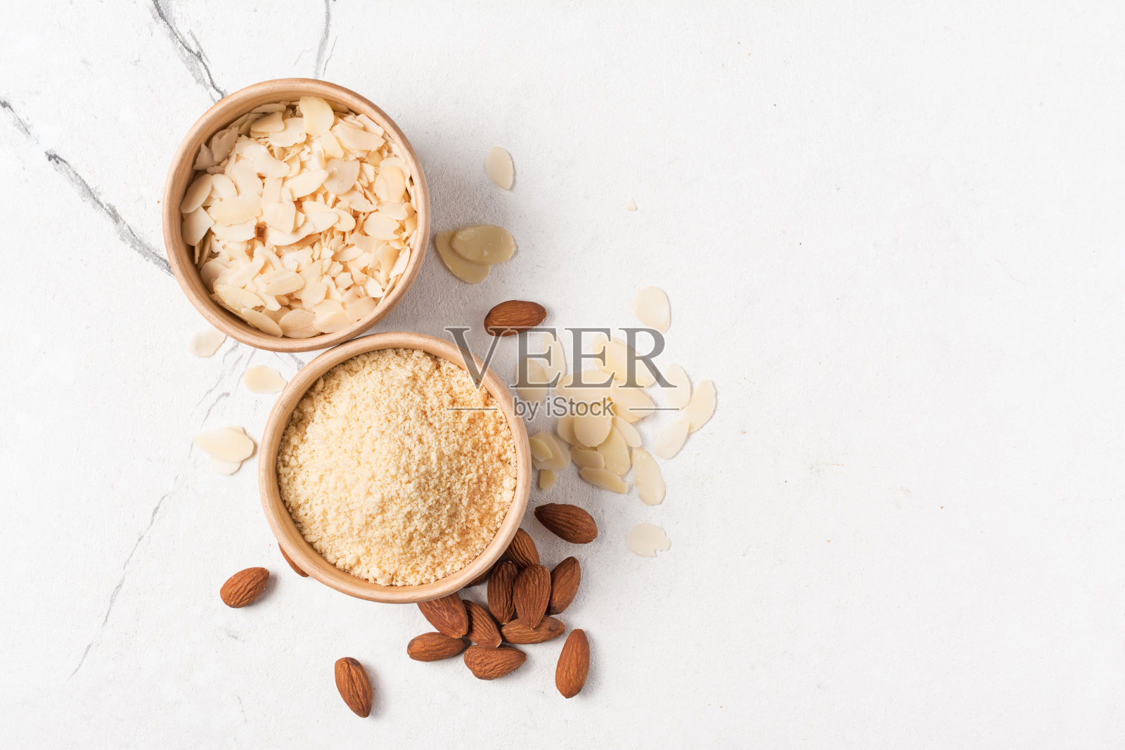 碗中杏仁粉和带整粒坚果的切片的顶视图照片摄影图片