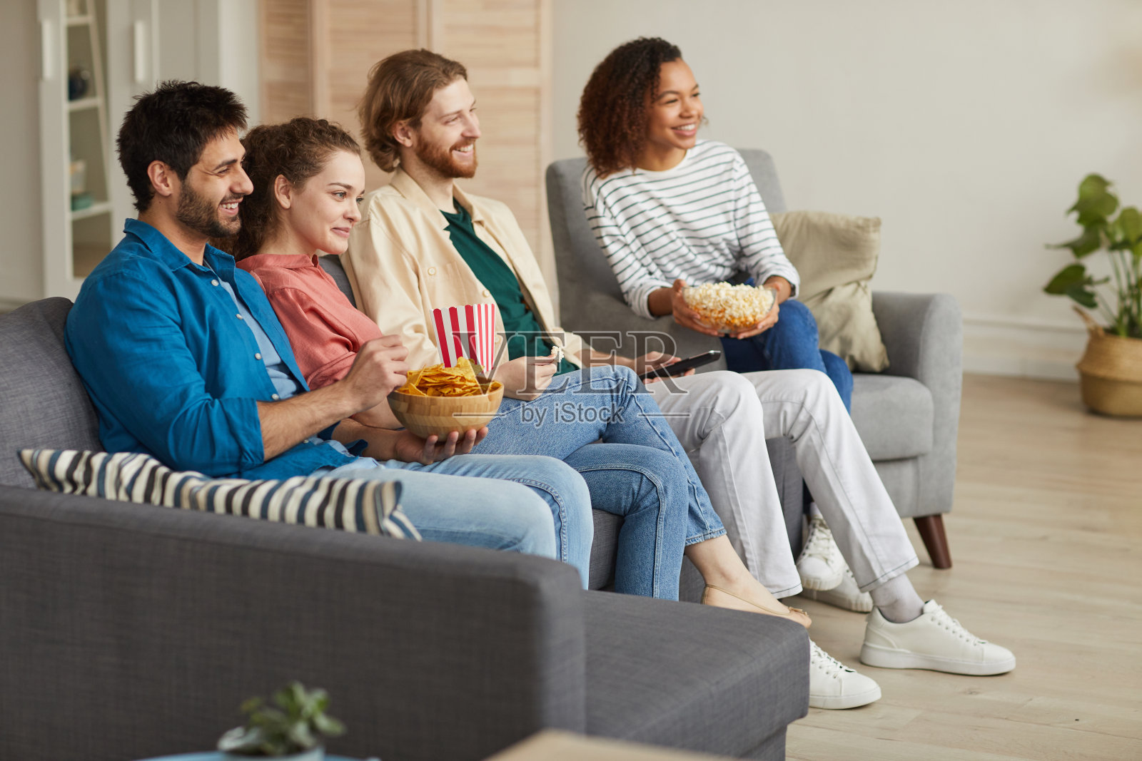 一群朋友在家里看电视照片摄影图片